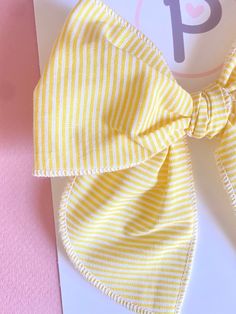 Yellow Striped Pattern  Fabric: Cotton  Sizing: - Mini: 4.5" x 4.5" - Regular: 5" x 5.5"  All items are handmade, and may contain slight variations in fabric placement. Due to different monitors and devices, colors way vary slightly. I recommend only baby or mini on nylon WARNING:  CHOKING HAZARD - Small parts Clips are not intended for children under 3 years old. It is recommended that all products should be used with adult supervision. Summer Decorative Bow Headband, Summer Bow Headband, White Decorative Bow Hair Accessories For Summer, White Bow Tie Hair Accessories For Summer, White Hair Accessories With Decorative Bow For Summer, Playful Bow Headband Hair Accessory, Cute White Bow With Ribbon, Summer Hair Accessories With Decorative Bow For Gifts, Cute White Ribbon Bow