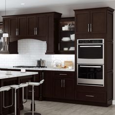 a modern kitchen with dark wood cabinets and white counter tops, along with stainless steel appliances