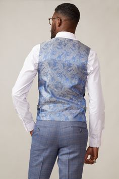 A formalwear staple, this Kelvin waistcoat epitomises versatility. In a classic navy, it is made for mix-and-match looks and breaks up patterns beautifully with its subtle textured fabric. The bespoke MD print lining adds elegance and with adjuster buckles to the each side you'll have the ability to create a perfectly contoured shape. Also available in a double-breasted option. Model wears size 38R. Features Slim fit Single-breasted 5 button fastening Complimentary pocket square Buckle adjuster Elegant Blue Nehru Jacket For Semi-formal Occasions, Elegant Semi-formal Suits With Vest, Elegant Tailored Three-piece Suit With Vest, Tailored Nehru Jacket For Business, Tailored Elegant Nehru Jacket For Business, Elegant Tailored Nehru Jacket For Business, Elegant Suits With Vest And Notch Lapel, Elegant Nehru Jacket For Business, Elegant Business Suit With Vest