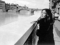 black and white photograph of a woman leaning on a bridge