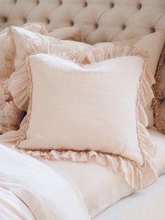 a bed with ruffled pillows and a teddy bear