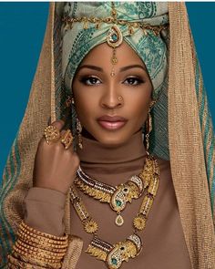 an african woman wearing gold jewelry and a headscarf