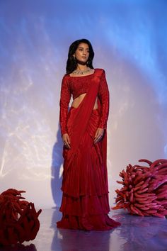 Embrace opulence with our exquisite Ruby Reef Drape Saree. Crafted from sumptuous red crepe silk, this alluring saree exudes elegance and allure. The heavy blouse adorned with intricate crystal beadwork and sparkling sequins adds a touch of glamour, making it a true statement piece. Immerse yourself in the luxurious fabric and unparalleled craftsmanship of this masterpiece, fit for a queen. Make a striking impression at any soirée or special occasion, as you gracefully drape yourself in the fine Red Cutdana Saree For Evening, Evening Red Saree With Cutdana, Red Evening Saree With Cutdana, Elegant Red Pre-draped Saree With Cutdana, Evening Red Blouse With Cutdana Detail, Red Sharara For Evening With Traditional Drape, Red Sharara With Traditional Drape For Evening, Elegant Red Georgette Choli, Elegant Red Embellished Pre-draped Saree