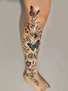 a woman's leg with butterflies and flowers on it