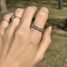 a woman's hand with two different rings on it, one is holding the other