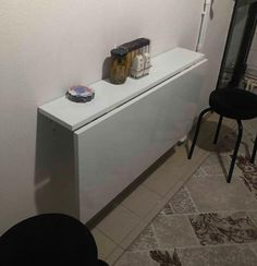 a white radiator sitting on top of a counter next to a black stool