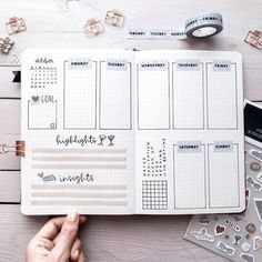 someone is holding up a planner with stickers on it, and there are other items surrounding the page