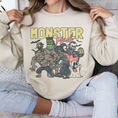 Get ready to be OBSESSED with your new favorite Monster Mash Sweatshirt. It's the cutest and most trendy way to emit all those retro Halloween Spooky Season vibes! Crafted from the softest fabric, this Gildan 18000 sweatshirt ensures the utmost comfort throughout the day. * Q U I C K F A C T S * ✺ 50% Polyester, 50% Cotton ✺ Wash and dry on delicate, inside out (on cool for best results) * S I Z I N G * ✺ Models are wearing size Large ✺ Sizing is unisex so runs like men's, though not overly larg Halloween Aesthetic Vintage, Jumpsuit Winter, Sweatshirt Graphic, Monster Characters, Monster Mash, Halloween Monster, Halloween Inspo, Halloween Aesthetic, Sweatshirt Halloween