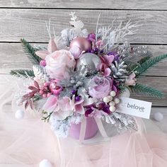 a bouquet of flowers in a pink vase with a sign that says below it on a white background