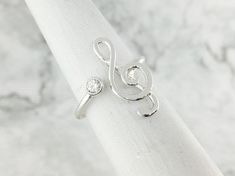 🎶 Music Note Ring 🎶Treble Clef Birthstone Ring handmade of sterling silver. A perfect gift for the musically inspired! You can choose your birthstone color from the drop-down menu along with your ring size. Everything in our shop is handmade in our studio, so this ring will be made to order in your size. Because of the open band design, it is slightly adjustable in size :)D E T A I L S• Music Note is .75 inches from top to bottom• Adjustable open band design• Made to order in your size• Person Music-themed Silver Ring As A Gift, Silver Music-themed Rings For Gifts, Music-themed Silver Rings As Gifts, Music-themed Silver Rings For Gifts, Music-themed Silver Rings For Gift, Treble Clef Ring, Music Note Ring, April Birthstone Ring, Paw Print Bracelet