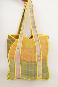 This bag is made from a vintage hand-stitched Kantha quilt. We make only 1-2 bags from each quilt and every one of them is one of a kind! Details: Shell fabric- Vintage quilted cotton Kantha 1. width (cm) - 35 2. height (cm)- 45 3. depth (cm) - 35 4. weight (g)- 0.400 kg 5. length of shoulder (cm) -25 cm Care instructions: Dry clean or Hand-wash in warm water. Drip dry. How it's made: Kantha quilts are made using numerous layers of recycled silk or cotton saris which are hand-stitched in the tra Green Quilted Square Bag, Square Green Quilted Bag, Green Quilted Rectangular Bag, Vintage Yellow Bag With Removable Pouch, Vintage Green Square Bag, Vintage Square Green Bag, Upcycled Multicolor Tote Bag, Rectangular Upcycled Bag For Daily Use, Rectangular Upcycled Bags For Daily Use