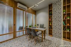 a dining room table with chairs and bookshelves