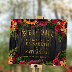 a wooden sign with flowers on it that says welcome to the wedding of elizabeth and nathan