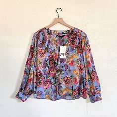 Flowy V-Neck Blouse With Ruffes And Long Sleeves. Vibrant Print V-neck Top For Brunch, Blue Floral Print V-neck Blouse, Blue V-neck Blouse For Fall, Multicolor V-neck Workwear Blouse, Multicolor V-neck Blouse For Work, V-neck Blouse With Vibrant Print For Day Out, Orange Printed V-neck Blouse, Blue V-neck Blouse For Brunch, V-neck Blouse With Vibrant Print For Brunch