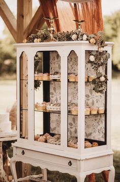 an old china cabinet with cupcakes on it