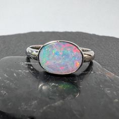 Pastel boulder opal statement ring in 14k white gold. Full face Australian boulder opal bezel set in 14k white gold with large band. Devine pastel colors in this juicy full face boulder opal!  Nice 3mm x 1.45 mm half round solid 14k gold band Comfort fit bezel to protect that beauty. 3 grams of 14k white gold 10.42mm x 7.62mm 3.32mm full face boulder opal weighing 2.37 carats. Currently US size 8 (select size at checkout) Elegant Iridescent Cabochon Opal Ring, Spiritual Silver Opal Ring With Multi-stone, Opal Statement Ring, Luxury Multi-stone Opal Ring Collectible, Boulder Opal Jewelry, Gem Shop, Australian Boulder Opal, Full Face, Boulder Opal