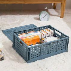 a blue crate sitting on top of a white rug next to a clock and other items