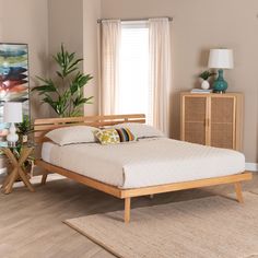 a bed sitting on top of a wooden floor next to a dresser and window in a bedroom