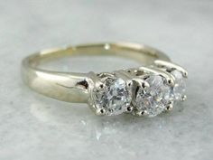 This classic vintage engagement ring is simple and traditional, crafted from 14 karat white gold. The three stones represent the past, present and the future. This will look well with a variety of wedding bands, from the ornate to the simple! Metal: 14K White Gold Gem: Center Diamond .39 Carats, SI3 in Clarity, E in Color Gem Measurements: 4.6 mm Round Accents: 2 Diamonds totaling .58 Carats, SI1 in Clarity, E in Color Ring Size: 4.50 Marks: "14K GTR" Stamped on the inside band Three Diamond Engagement Ring, Engagement Ring Diamond, Vintage Engagement Ring, Past Present Future, Colored Gems, Vintage Engagement, Ring Diamond, Color Ring, Vintage Engagement Rings