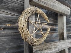 a wicker star hanging on the side of a wooden wall next to a fence