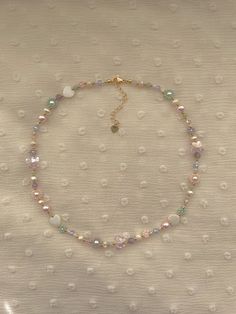 "This necklace features an assortment of pastel seed bead colors and 24k shiny and matte gold plated seed beads. It also contains freshwater Pearls, green jade, white shell hearts, rose quartz, pink faux pearls, amethyst,  and an assortment of glass crystals. ✨ Length: 15\" inches Seed Bead Size: 11/0, 3mm, 5mm Adjustable: Each necklace has a 2.5\" gold filled lobster clasp extender Strung on: Non-Stretchy Beading Thread" Aesthetic Necklaces Beads, Seed Bead Inspo Aesthetic, How To Make Bead Necklaces, Dainty Beaded Jewelry, Dainty Beaded Necklace, Necklace Inspo Beads, Necklace Beads Ideas, Cute Beaded Necklaces, Beads Necklace Design