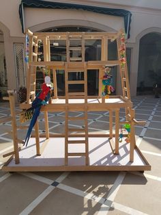 a wooden structure with two parrots perched on it's perches in front of a building