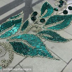 green and silver beaded jewelry laying on the ground