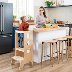 a woman and child are standing at the kitchen island in front of the counter top