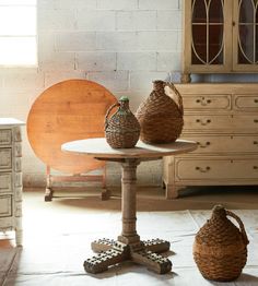 two vases sitting on top of a wooden table next to a white brick wall