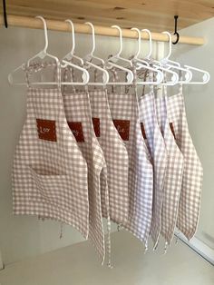 several aprons hanging on a rack in a kitchen