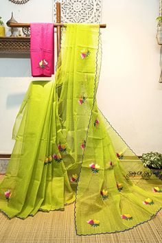 Embroidery work on green and yellow cross tone handloom resham cotton kota saree. Floral design has been neatly and densely done with multi color threads. The bright color combination and the scalloped border with all over floral motifs make this saree very elegant. this saree comes with an embroidered contrast cotton blouse piece. This saree is light weight, very comfortable & easy to drape. Details: *Fabric: Handloom Resham by cotton kota saree *Work: Machine Embroidery work [*this work is neither Computerized Machine Embroidery work nor machine Aari Embroidery with woolen thread. * It's completely Manual Machine Embroidery Work with silk threads.] *Blouse: With embroidered cotton blouse piece *Saree length: 5.5 mtrs *Saree width: 47 inches *Blouse piece length: 1 mtr *Blouse piece width Green Resham Embroidered Cotton Silk Blouse Piece, Semi-stitched Green Embroidered Fabric With Self Design, Embroidered Green Cotton Silk Traditional Wear, Green Resham Embroidery Saree For Puja, Pista Green Cotton Dupatta With Resham Embroidery, Pista Green Cotton Silk Saree With Resham Embroidery, Green Zari Work Mulmul Dupatta, Green Chikankari Embroidery Fabric For Diwali, Yellow Chikankari Embroidery Cotton Silk Saree