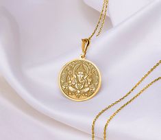 This intricate Ganesh pendant, handcrafted with devotion, embodies the spirit of the elephant-headed god.  Known as the remover of obstacles and the bringer of good luck, Ganesh is a cherished figure in Hinduism. Wear this pendant as a symbol of new beginnings, wisdom, and prosperity. * Gender : Male / Female * Material Options : 14K Solid Gold , 925 Sterling Silver, 14K Gold Plated , Rose Plated  * Gold plated and rose gold plated options are 14 carat and are made on silver. * The thickness of Spiritual Round Pendant Necklace For Diwali, Temple Jewelry Locket For Meditation, Festival Coin Pendant Jewelry As Gift, Festival Gift Jewelry With Coin Pendant, Festival Coin Pendant Jewelry Gift, Round Temple Necklace For Navratri Gift, Navratri Gift Temple Necklace, Festival Temple Necklace With Large Pendant As Gift, Hallmarked Amulet Necklace For Puja