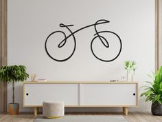 a living room with a large wall mounted bike on it's sideboard and potted plants