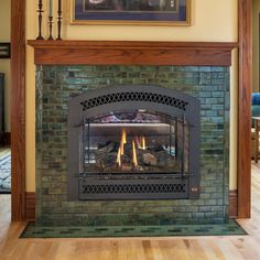 a fire place in a living room with wood flooring and a painting on the wall