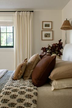 a bed with many pillows on top of it