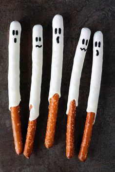 three pretzels with faces painted on them are lined up in the shape of marshmallows