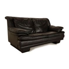 a black leather couch sitting on top of a white floor