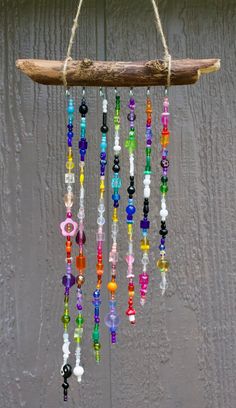 a wind chime hanging from a tree branch with colorful beads and glass beads on it