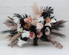 an arrangement of flowers and feathers on a white background