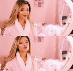 a woman with long hair wearing a pink robe in front of a mirror