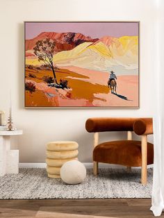 a living room with a painting on the wall and a chair in front of it