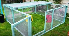 two large blue cages in the grass near a house