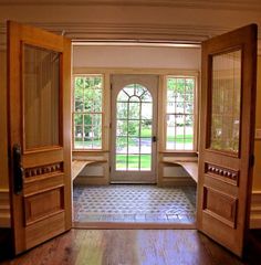 an open door leading into a large room with wooden floors and doors on both sides