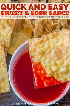 a bowl filled with red sauce next to some crackers