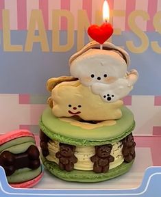 there is a small cake with two teddy bears on it and a lit candle in the middle