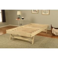 a wooden bed frame sitting on top of a rug in a living room next to a lamp