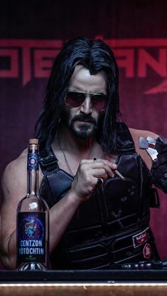 a man with long black hair holding a bottle