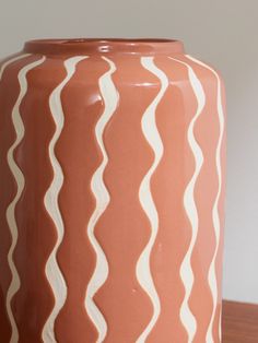 a brown vase sitting on top of a wooden table