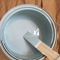 a paint can with a wooden spatula in it