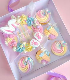 cupcakes decorated with pastel colors in a box